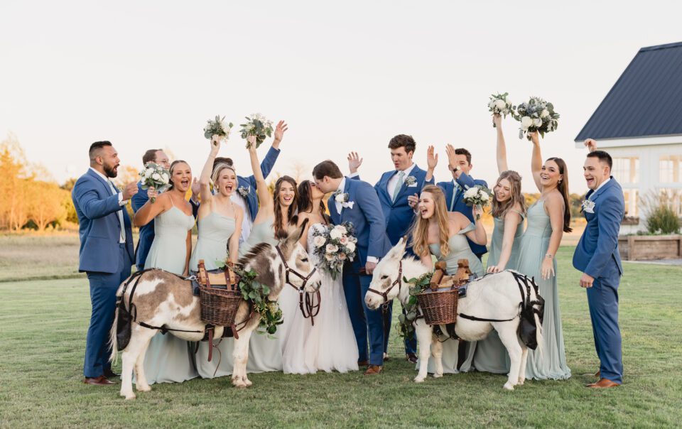 a group of people posing for a photo with donkeys and flowers. Photography Locations wedding photography packages by Bushel + Peck Photo