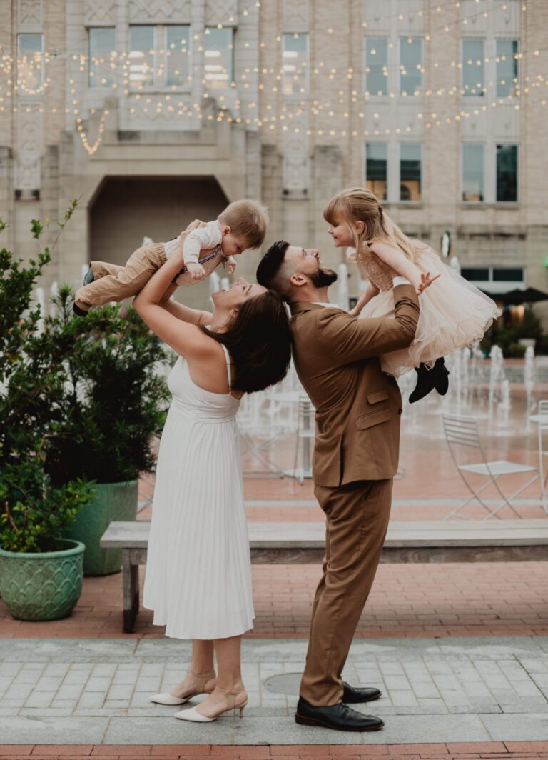 a man and woman holding two children. portrait session pricing Portrait Photography Portrait Photographers by Bushel + Peck Photo