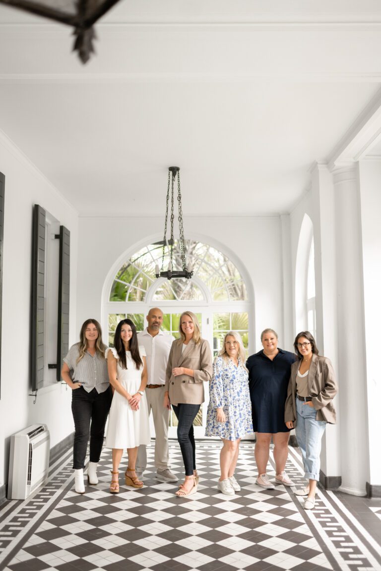 a group of people standing in a room with windows. Bushel + Peck Photo Team.