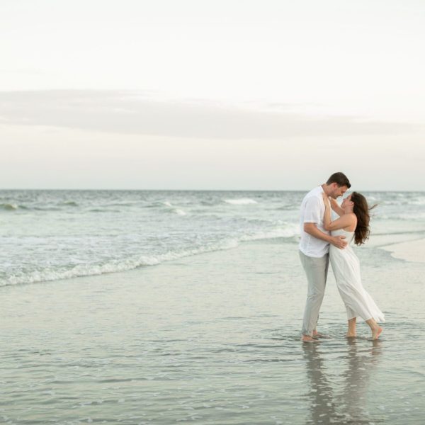 a man and woman hugging on a beach for beach vacation photography by Bushel + Peck Photo